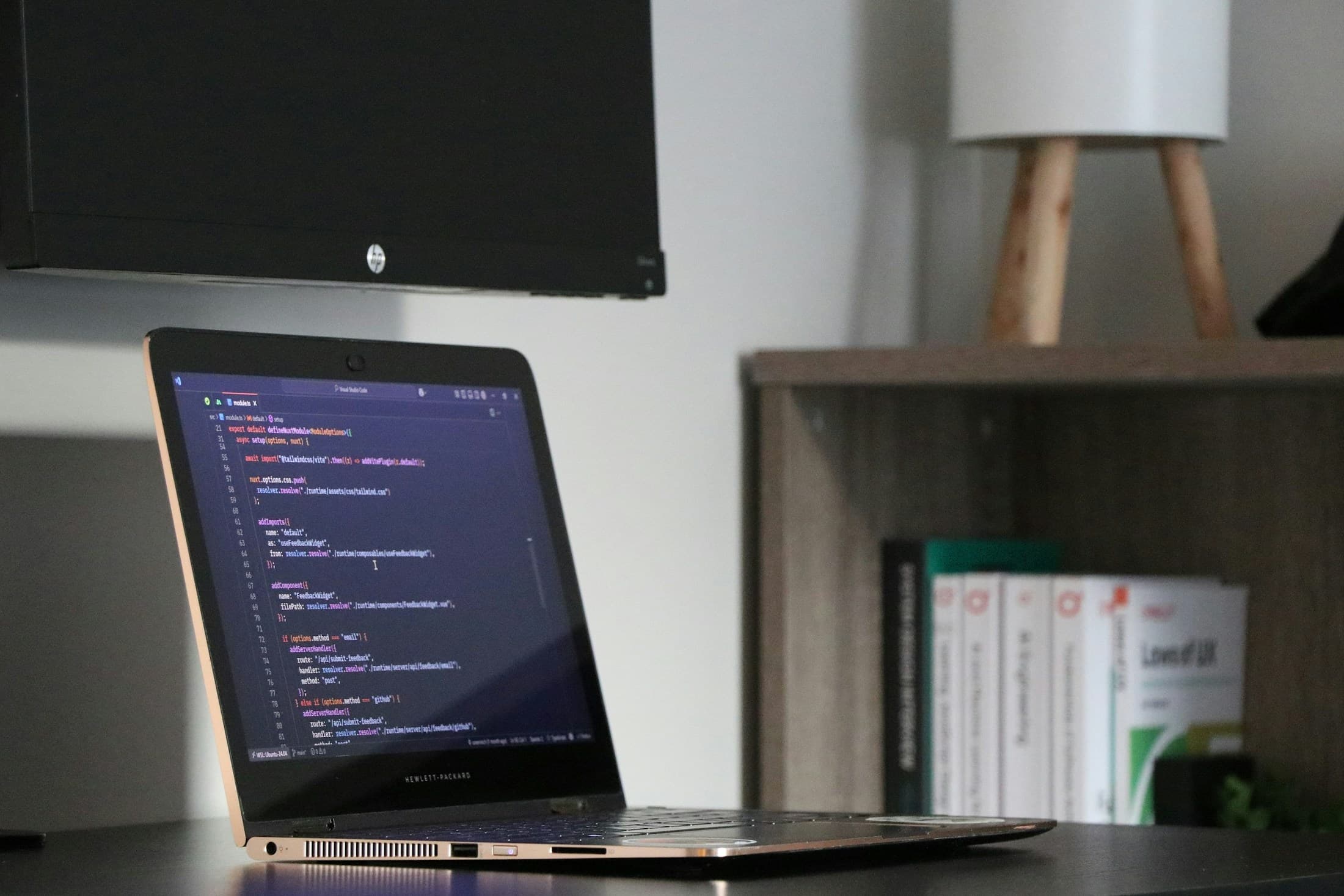 Laptop mit geöffnetem Code-Editor an einem Arbeitsplatz